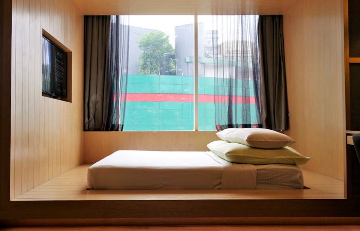 El hotel WOLO de Kuala Lumpur cuenta con habitaciones elegantes y sobrias con camas de plataforma. 