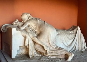 Escultura de mármol de una mujer besando a un moribundo