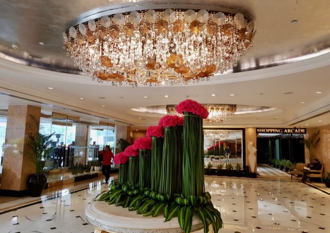 El opulento vestíbulo cuenta con suelos de mármol y un enorme candelabro.