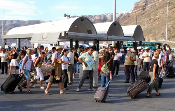 Los propietarios de hoteles se encuentran con los pasajeros del ferry que llegan en Santorini.