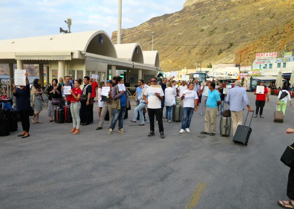 Los propietarios de hoteles se encuentran con un ferry que llega a Santorini.
