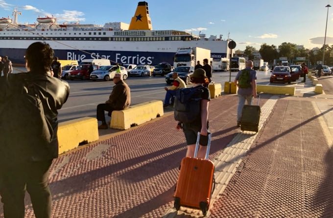 Viajeros con maletas caminando hacia un ferry