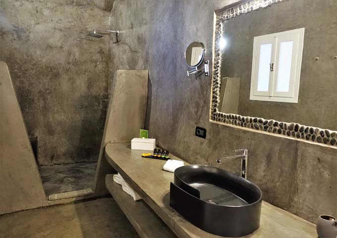 Los baños son de estilo cueva con ducha abierta y accesorios modernos.