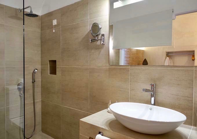Los baños de las suites cuentan con duchas de efecto lluvia abiertas de estilo griego.
