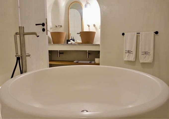 La bañera redonda y los lavabos dobles de terracota son increíbles.