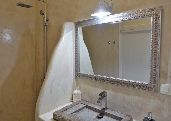Los baños de la villa tienen duchas de estilo cueva y lavabos de roca.