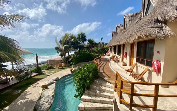 Balcón aterrazado con vistas a una playa bordeada de palmeras