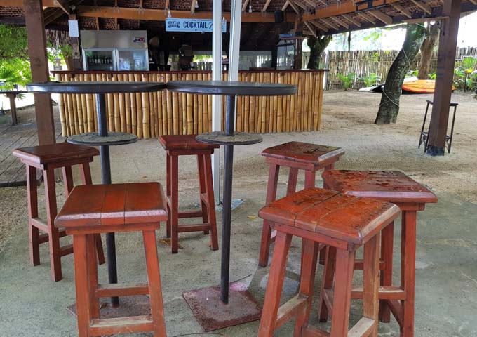 El bar al aire libre es tropical con arena y madera.