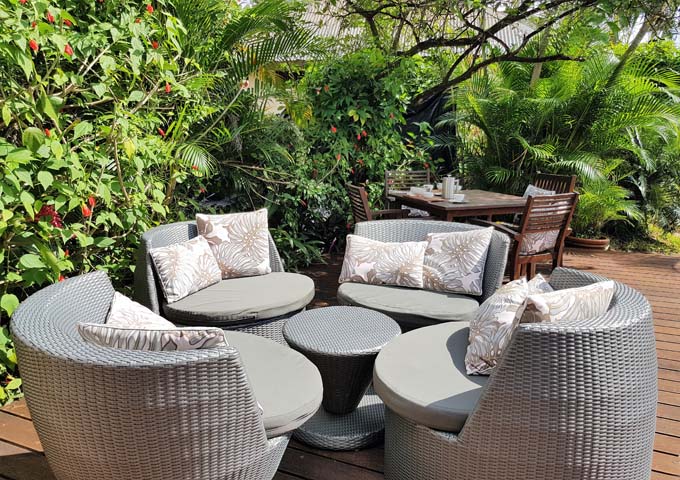 Los huéspedes del bar pueden relajarse en la terraza de madera entre jardines tropicales.