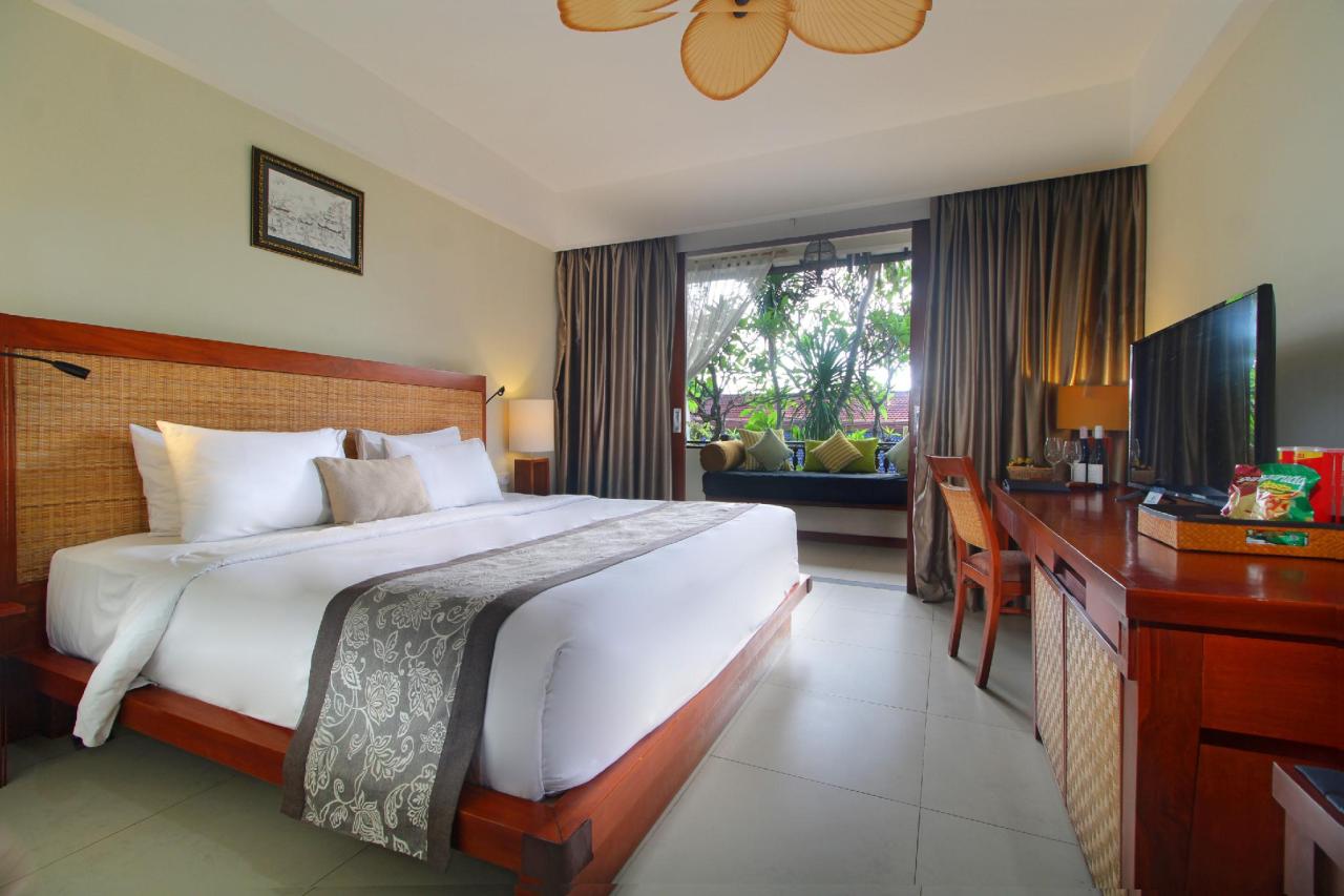 Habitación con cama grande y comoda, television y bien iluminada en el hotel Kuta Seaview Boutique Resort en Bali