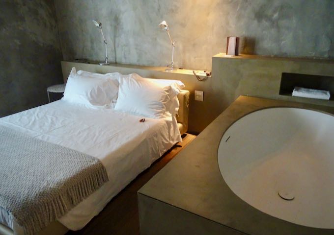 Habitación de hotel minimalista con cama doble y bañera en la habitación