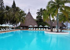 Piscina con isla de palmeras en Le Méridien Noumea Resort & Spa.