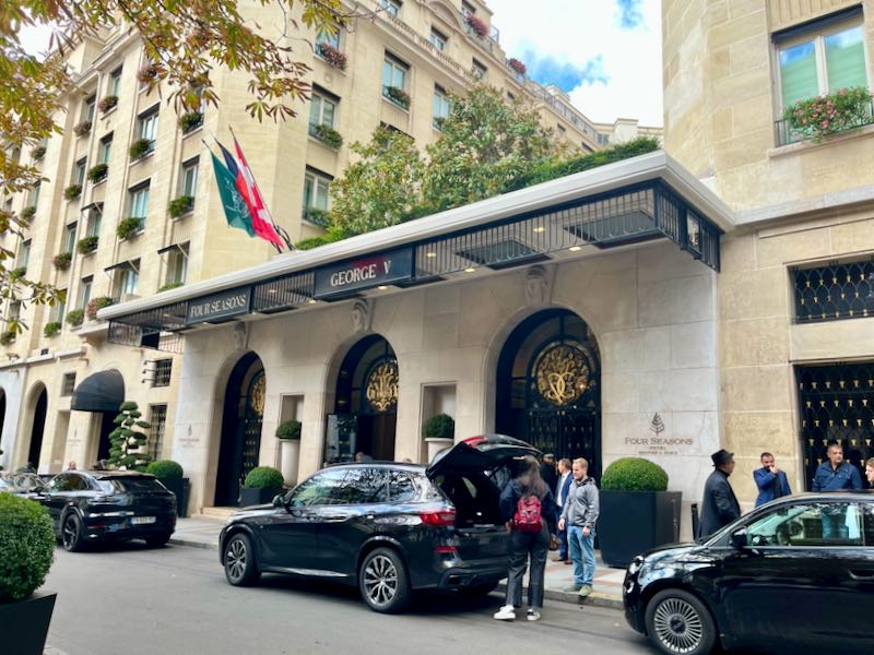 La gente descarga el equipaje del maletero de un automóvil en la ornamentada entrada del Hotel Four Seasons en París.