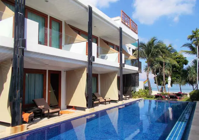 Habitaciones con acceso a la piscina y vista al mar en un resort moderno y conveniente